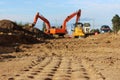 imprints of traces of heavy equipment in the sand. working excavators in the background. repair and construction of a
