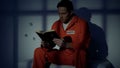 Imprisoned religious male reading bible, convicting in sins, feeling guilty Royalty Free Stock Photo