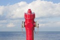 An improbable hydrant at the seaside - Plenty of water concept image with red hydrant against ocean Royalty Free Stock Photo