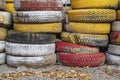 An impromptu fence made of old waste car tires, which are painted in different colors. Royalty Free Stock Photo