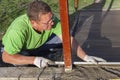 Improvement of the yard, a man evens out the concrete mortar with the rule