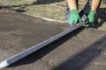 Improvement of the yard, a man evens out the concrete mortar with the rule