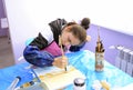 Improving motor control. Disabled girl painting picture with a brush and colors. Municipal Department of rehabilitation