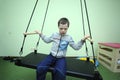 Improving motor control: Down syndrome boy doing exercises at the rehabilitation room