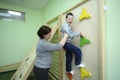 Improving motor control: Down syndrome boy doing exercises at the rehabilitation room