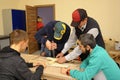 Improving motor control. Man therapist teaching disabled boys of working with a drill at the carpentry workhop