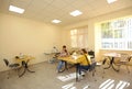 Improving motor control. Woman therapist teaching disabled girls of tailoring at the sewing workhop. Municipal