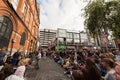 Improvised concert in Dublin Temple Bar with a crowd of people sitting and standing on the square steps by the excited buskers