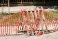 Improvised road construction site barrier with protective caution orange fence or net to protect street reconstruction work ahead Royalty Free Stock Photo