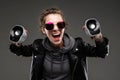 Impudent girl in glasses with portable speakers on a black background