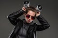 Impudent girl in glasses with two portable speakers on a black background