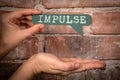 Impulse. Green speech bubble with text on a red brick background