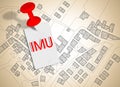 IMU which means Unique Municipal Tax the most unpopular italian tax on land and buildings - concept image against a cadastral