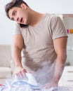 Inattentive husband burning clothing while ironing Royalty Free Stock Photo