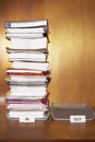 Inbox with stack of paperwork empty outbox on desk Royalty Free Stock Photo