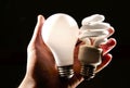 Incandescent and cfl lightbulb in human hand. Royalty Free Stock Photo