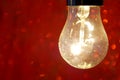 Incandescent lamp on a red background Royalty Free Stock Photo