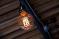 Incandescent lamps hang on the roof with blur brick wall in background. Edison lamp.