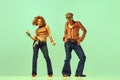 Incendiary dance. Emotional man and woman in retro style clothes dancing disco dance over green background. Concept of Royalty Free Stock Photo