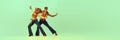 Incendiary dance. Emotional man and woman in retro style clothes dancing disco dance over green background. Concept of Royalty Free Stock Photo