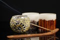 Incense holder with some candles on black background