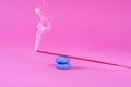 Incense red stick smoke on blue rock on pink Royalty Free Stock Photo