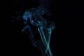 Incense stick with blue smoke against black background Royalty Free Stock Photo