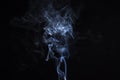 Incense stick with blue smoke against black background Royalty Free Stock Photo