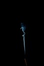 Incense stick with blue smoke trail isolated on black Royalty Free Stock Photo
