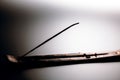 Incense stick on a wooden support on a white background