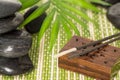 Incense sticks with black basalt stones and green leaf, on bamboo mat