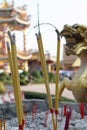 Incenses burnt halfway with Chinese temple structure on the background. Royalty Free Stock Photo