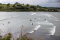 Inchydoney beach on an overcast day with people surfing, swimming and swimming