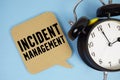 Incident Management text with alarm clock on blue background Royalty Free Stock Photo