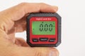 inclinometer, small safe level measuring device between fingers of a hand, 0Â° Royalty Free Stock Photo