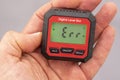 inclinometer, small safe level measuring device between fingers of a hand, error message. Royalty Free Stock Photo