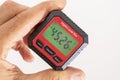 inclinometer, small safe level measuring device between fingers of a hand, 45,26Â° Royalty Free Stock Photo