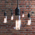 Included electric lamps on a brick wall background. Edison lamp Royalty Free Stock Photo