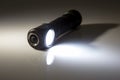 Included light beam flashlight on a dark background. camping and household item