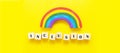 Inclusion concept word on wooden cubes and rainbow on yellow background, banner