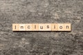 Inclusion word written on wood block. Inclusion text on cement table for your desing, concept Royalty Free Stock Photo