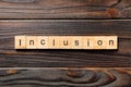 Inclusion word written on wood block. Inclusion text on wooden table for your desing, concept Royalty Free Stock Photo
