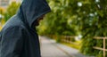 Incognito man in hoodie stay alone park outdoor alley greenery environment space without people here Royalty Free Stock Photo