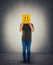 Incognito person holding a yellow box instead head. Introvert anonymous hiding face behind mask Royalty Free Stock Photo