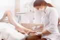 Brunette female podiatrist making polish and cleaning procedure Royalty Free Stock Photo