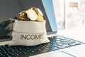 Income and business success concept with golden coins in income bag on laptop keyboard Royalty Free Stock Photo