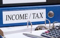 Income and Tax - blue binder with text in the office Royalty Free Stock Photo
