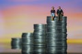 Income Tax Campaign Spain. Young Couple sitting on coin stack. Declaracion de la Renta. Macro