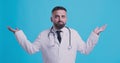 Incompetent medical doctor spreading his hands, blue background