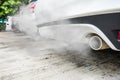 Incomplete combustion creates poisonous carbon monoxide from exhaust pipe of white car, air pollution concept Royalty Free Stock Photo